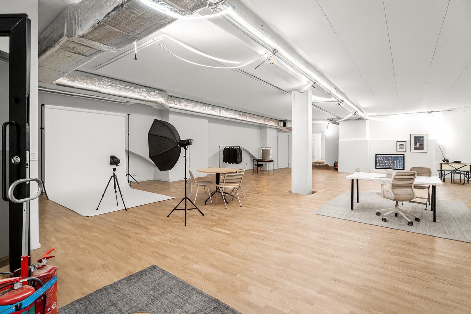 Luftig fotostudio med högt i tak, stora öppna ytor och modern belysning. En ideal miljö för skapande, event eller ateljéverksamhet.