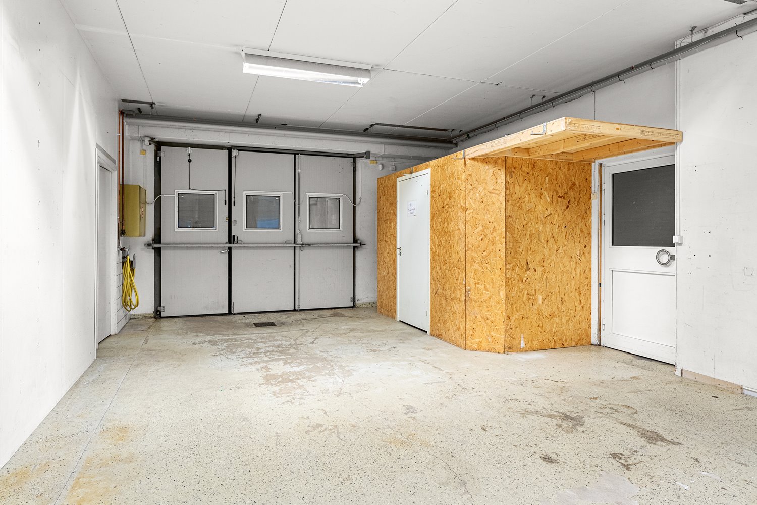 Rymlig lager- eller verkstadsyta med portar och god takhöjd, idealisk för logistik, produktion eller förvaring.