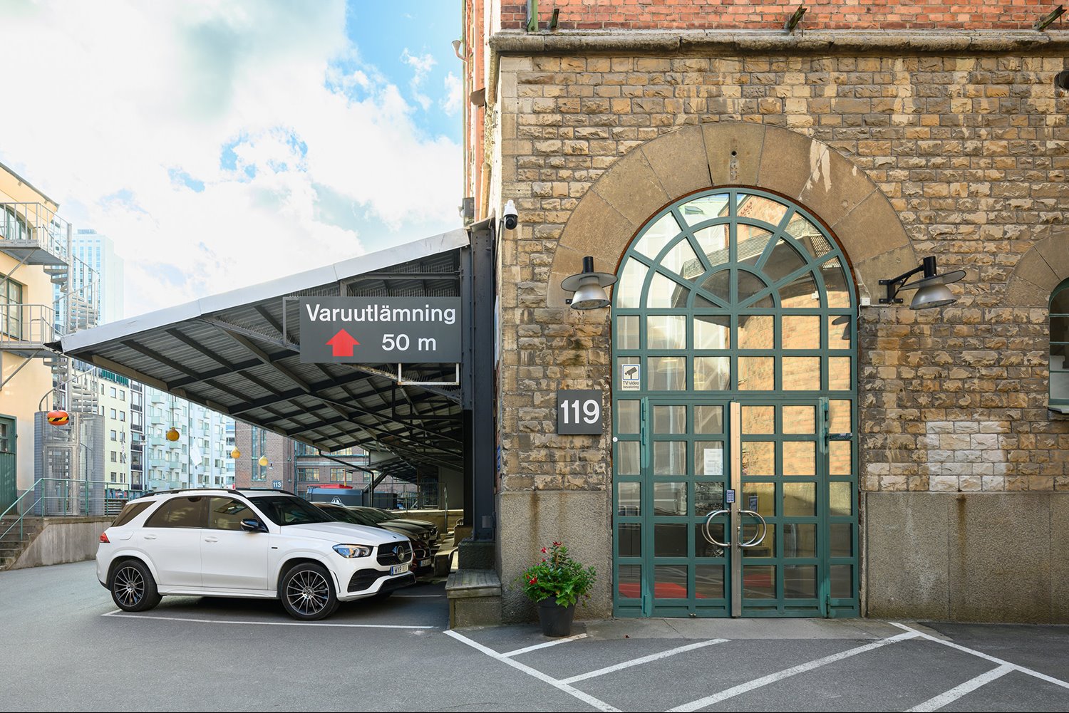 Entrén på Åsögatan 119 har vackra detaljer i sten och smide – ett elegant välkomnande för både personal och besökare.