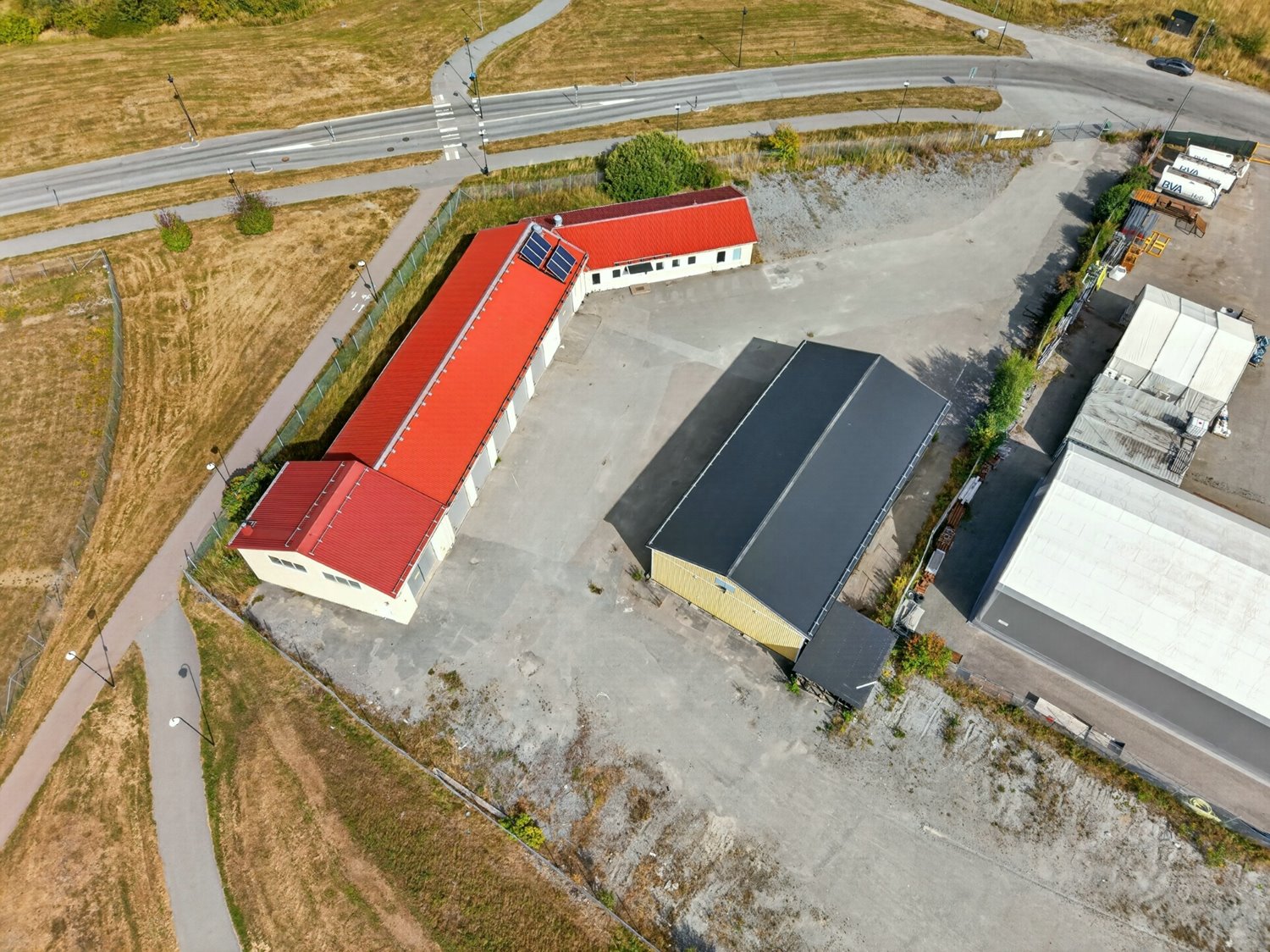 Rymlig inhägnad gård med flera verksamhetsbyggnader