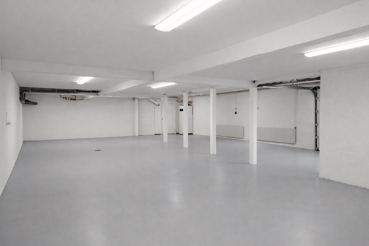 Effektiv lageryta med slitstarkt industrigolv och stabila pelare. Här finns gott om plats för förvaring, arbetsstationer eller verksamhetsyta.