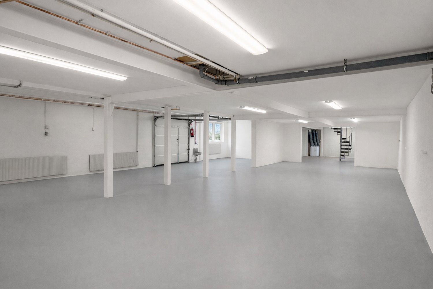 Praktisk lagerdel med port för smidig in- och utlastning. Nymålade väggar och nytt golv ger en ljus och fräsch arbetsmiljö.