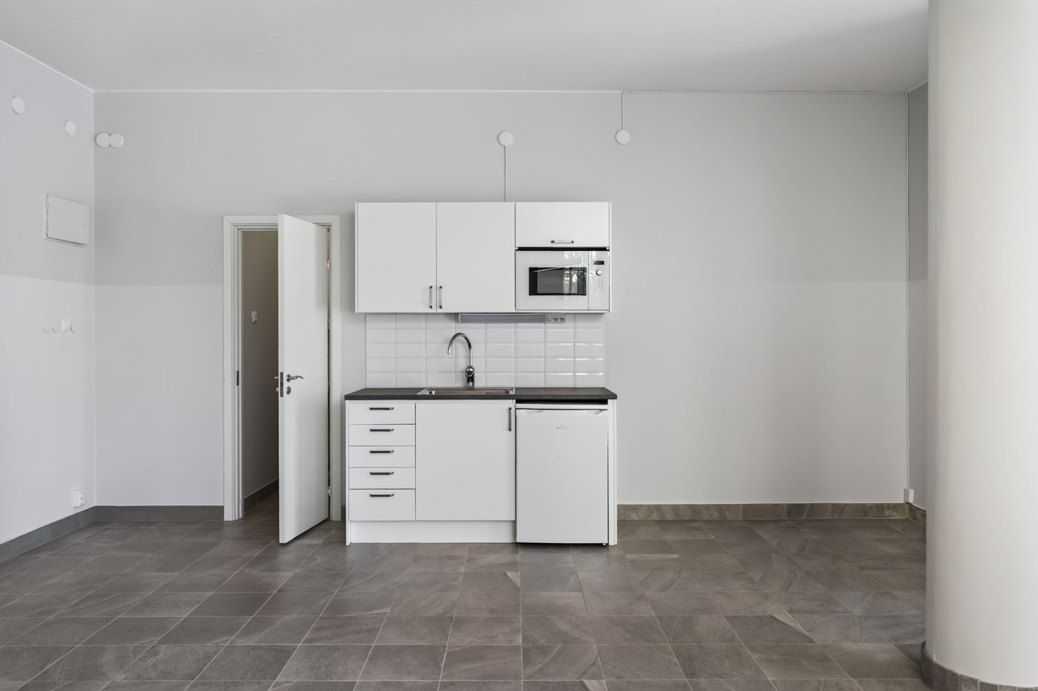 Eget pentry med god förvaring, diskho, mikrovågsugn och kylskåp – perfekt för arbetsdagens pauser.